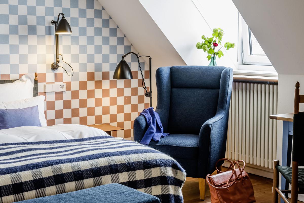 Gemütliches Zimmer im Kloster Hornbach mit kariertem Wandmuster und blauer Sitzgruppe