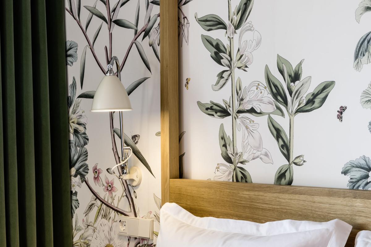 Modernes Schlafzimmer im Kloster Hornbach mit floraler Wandgestaltung und farbigen Kissen