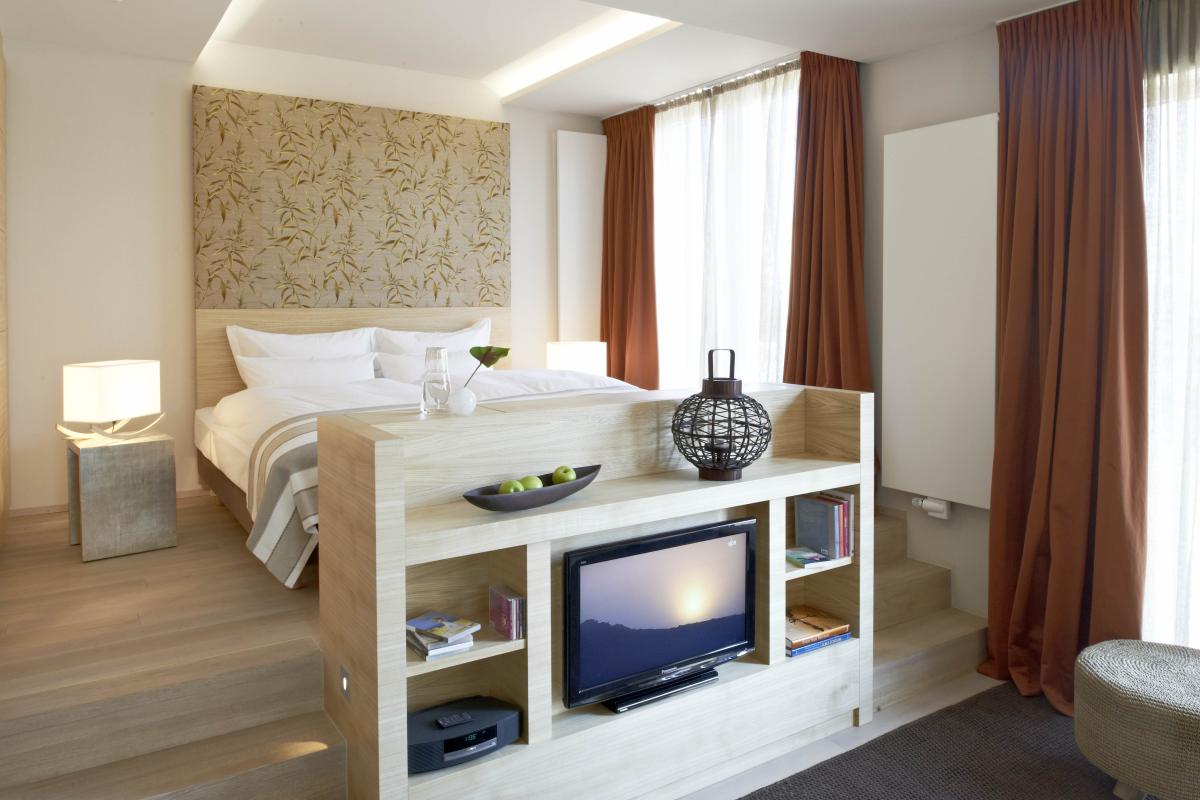 Modernes Hotelzimmer mit Lösch-Fernseher und warmen Vorhängen