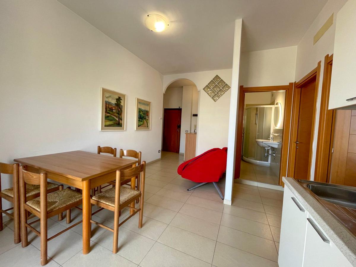 Zona pranzo con tavolo e sedie in legno a Evangelisti Casa Bellaria-Igea Marina