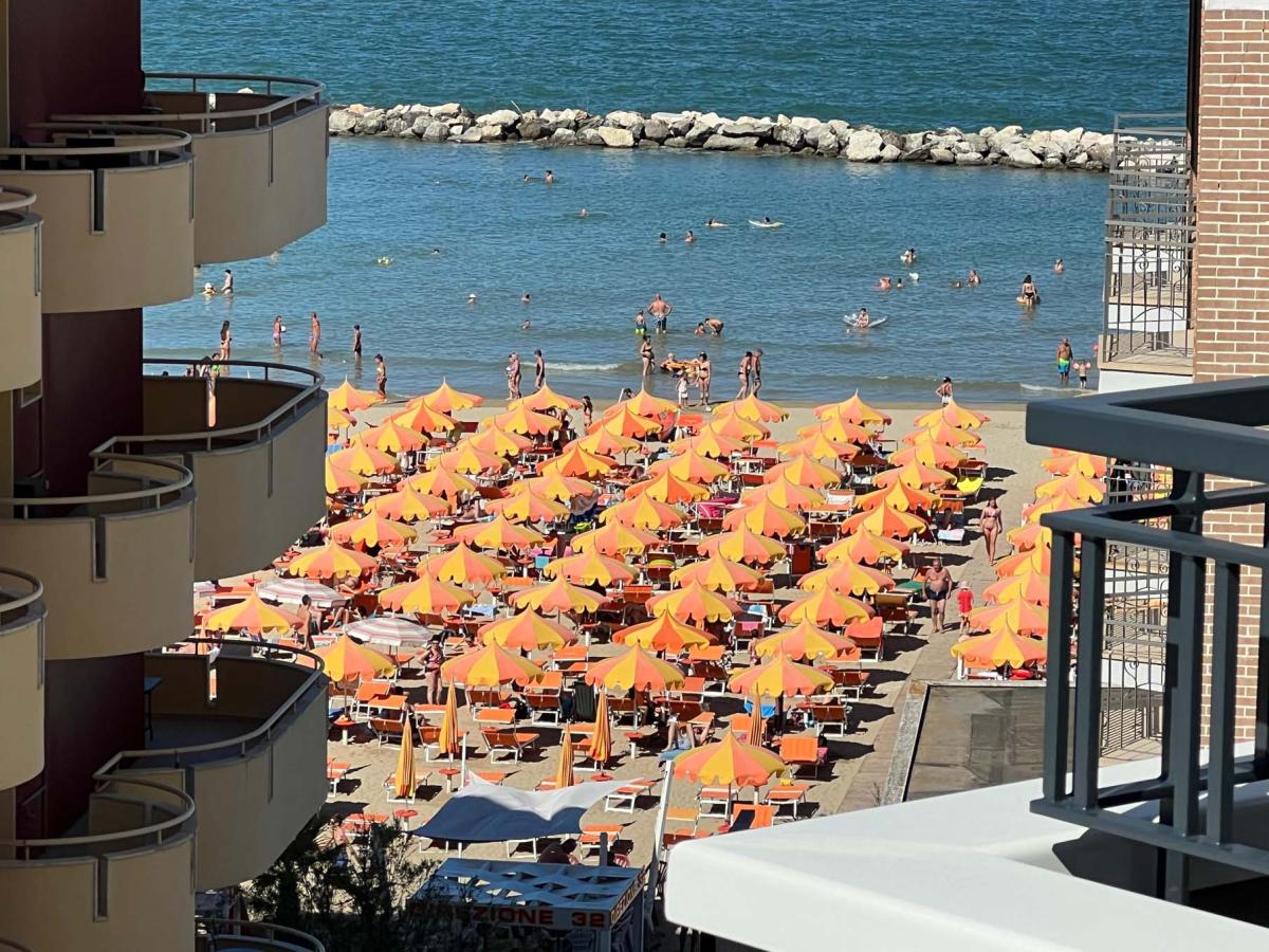 Evangelisti Casa vista sulla spiaggia con ombrelloni arancioni a Bellaria-Igea Marina