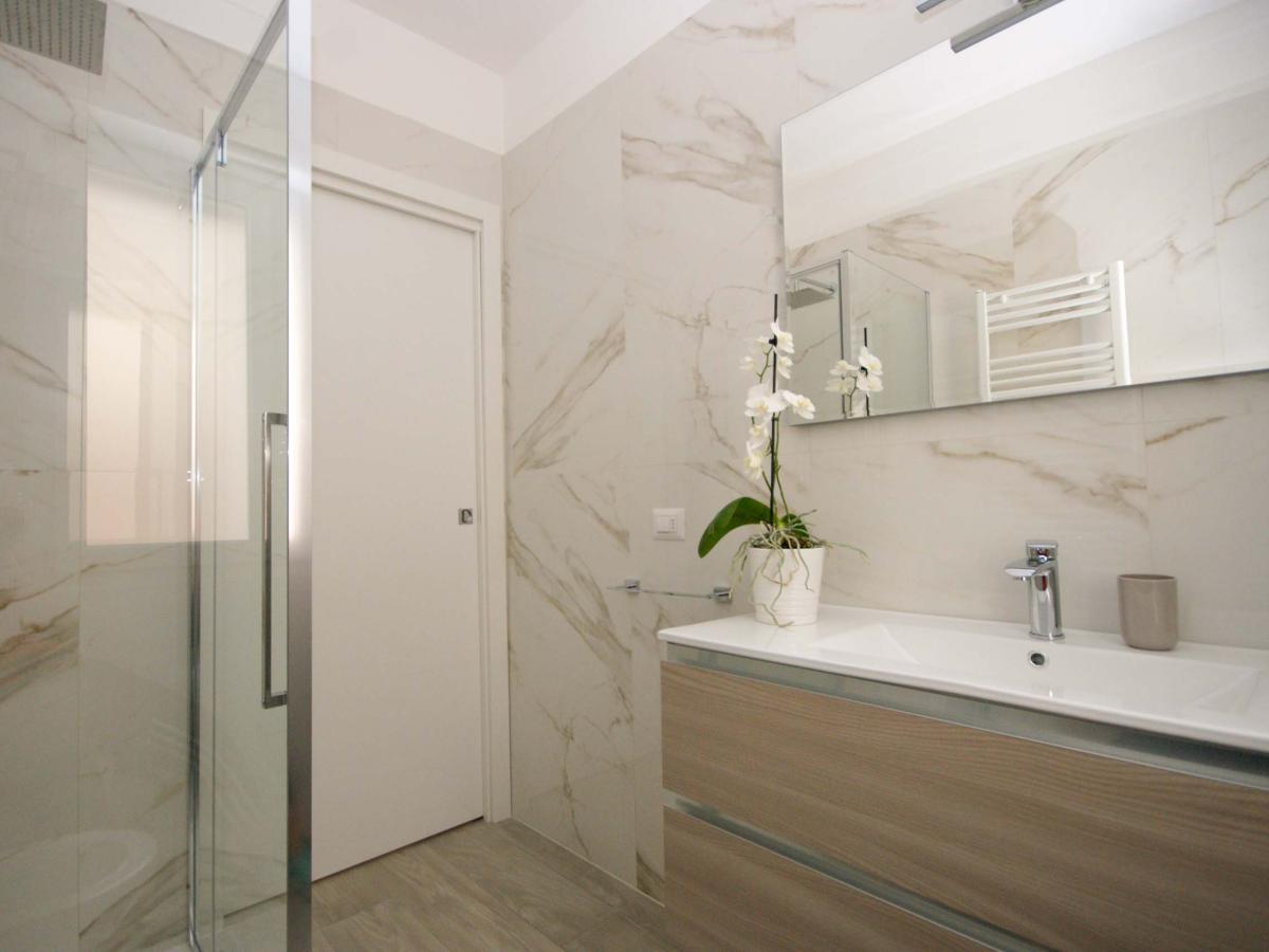 Bagno moderno con mobile in legno e orchidea presso Evangelisti Casa Bellaria-Igea Marina