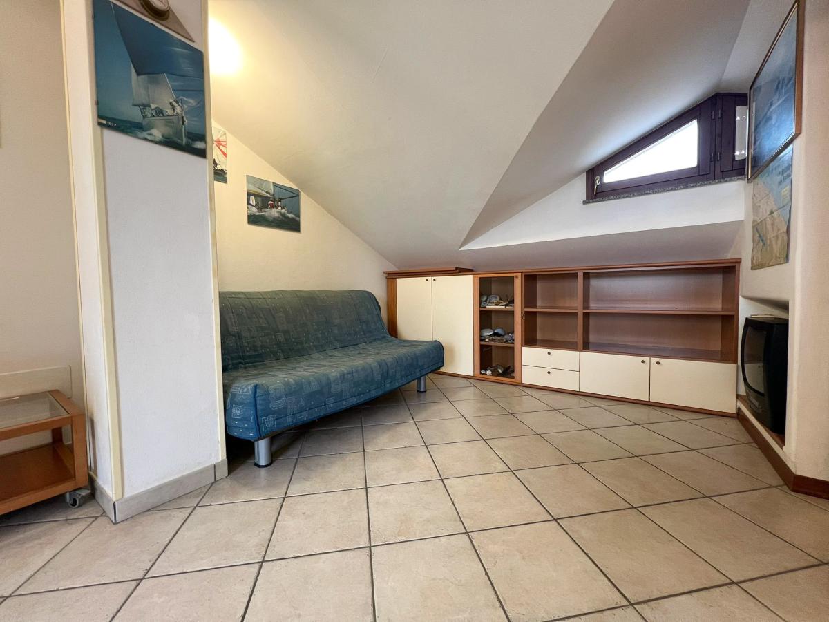 Piccola mansarda con divano blu e scaffali in legno Evangelisti Casa Bellaria-Igea Marina