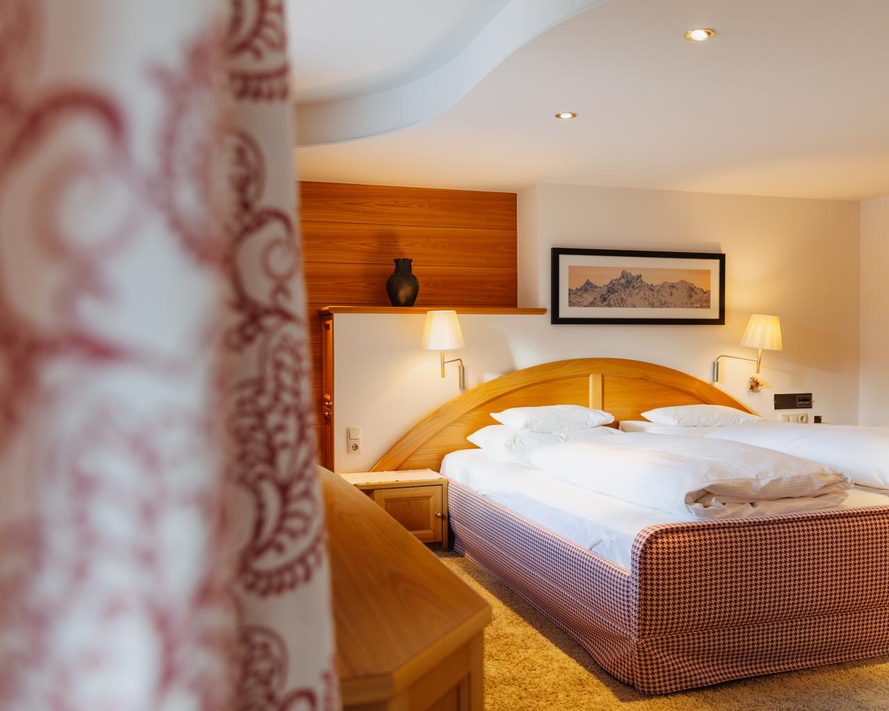 Cozy twin bedroom with wooden paneling at Hotel Aurora