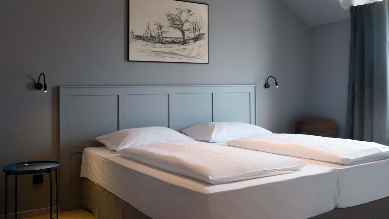 Schlichtes Schlafzimmer mit Doppelbett und Luis v. Weyden Kunst an der Wand