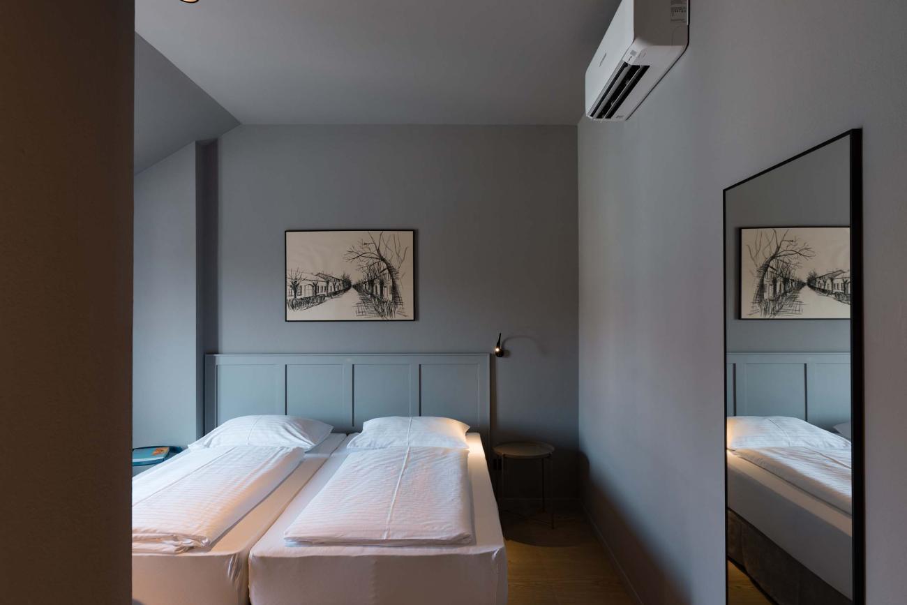 Schlafzimmer mit zwei Betten und Bild, Spiegel an der Wand, Luis v. Weyden