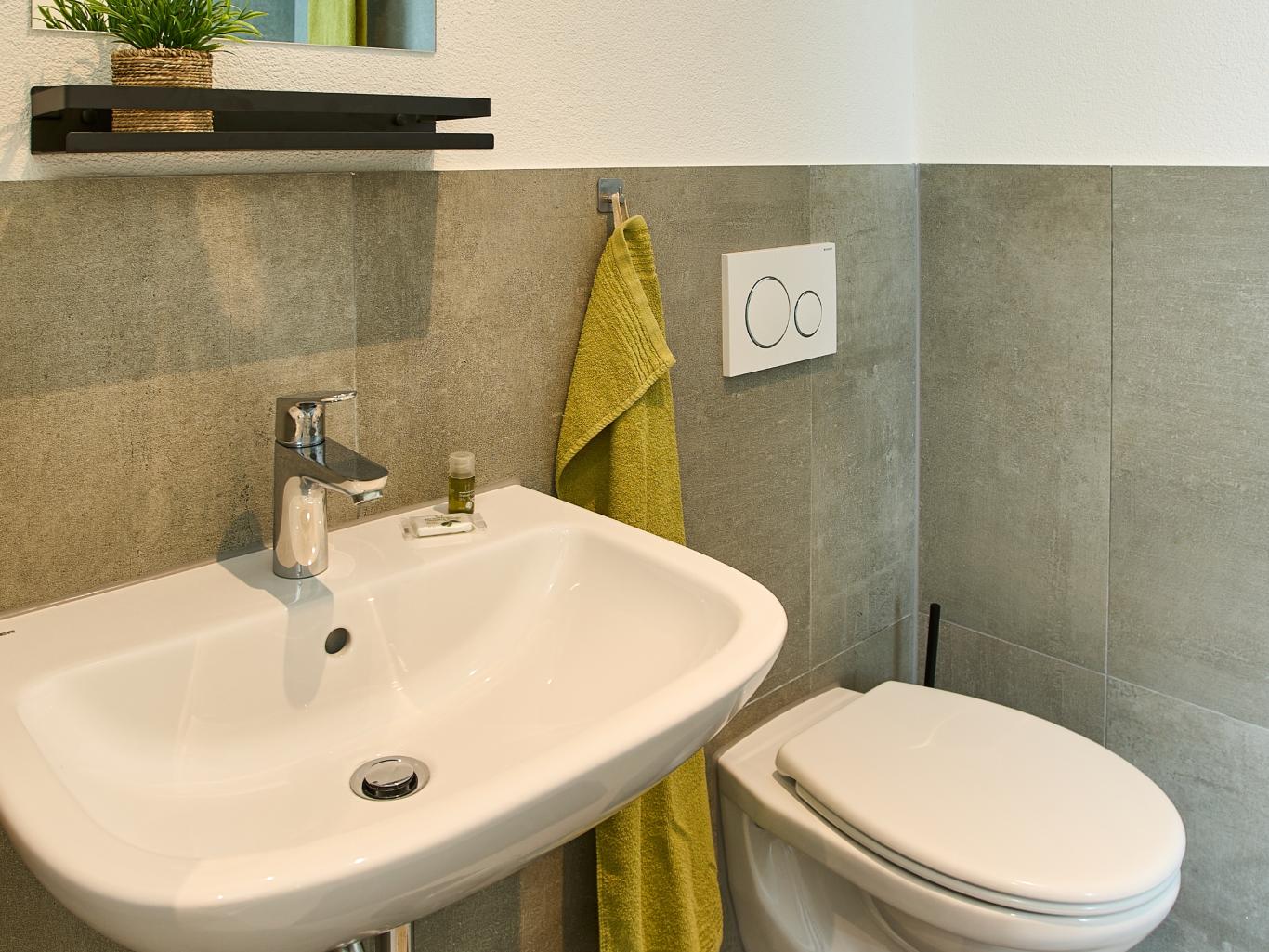 Modernes Bad mit Waschbecken, WC und Handtuch von LIVINGBOXX®