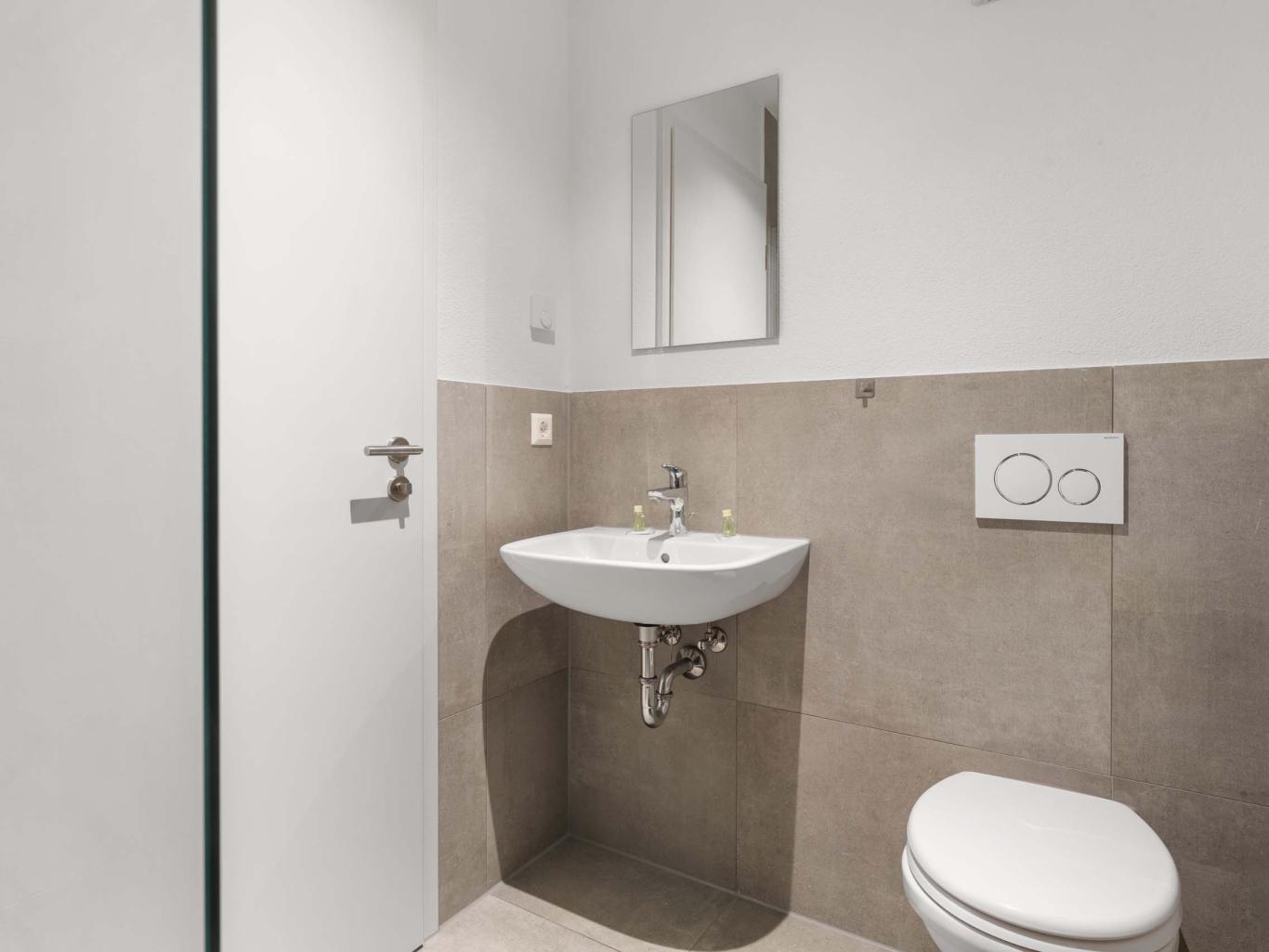 Modernes Badezimmer mit LIVINGBOXX® Waschbecken und WC in neutralen Tönen