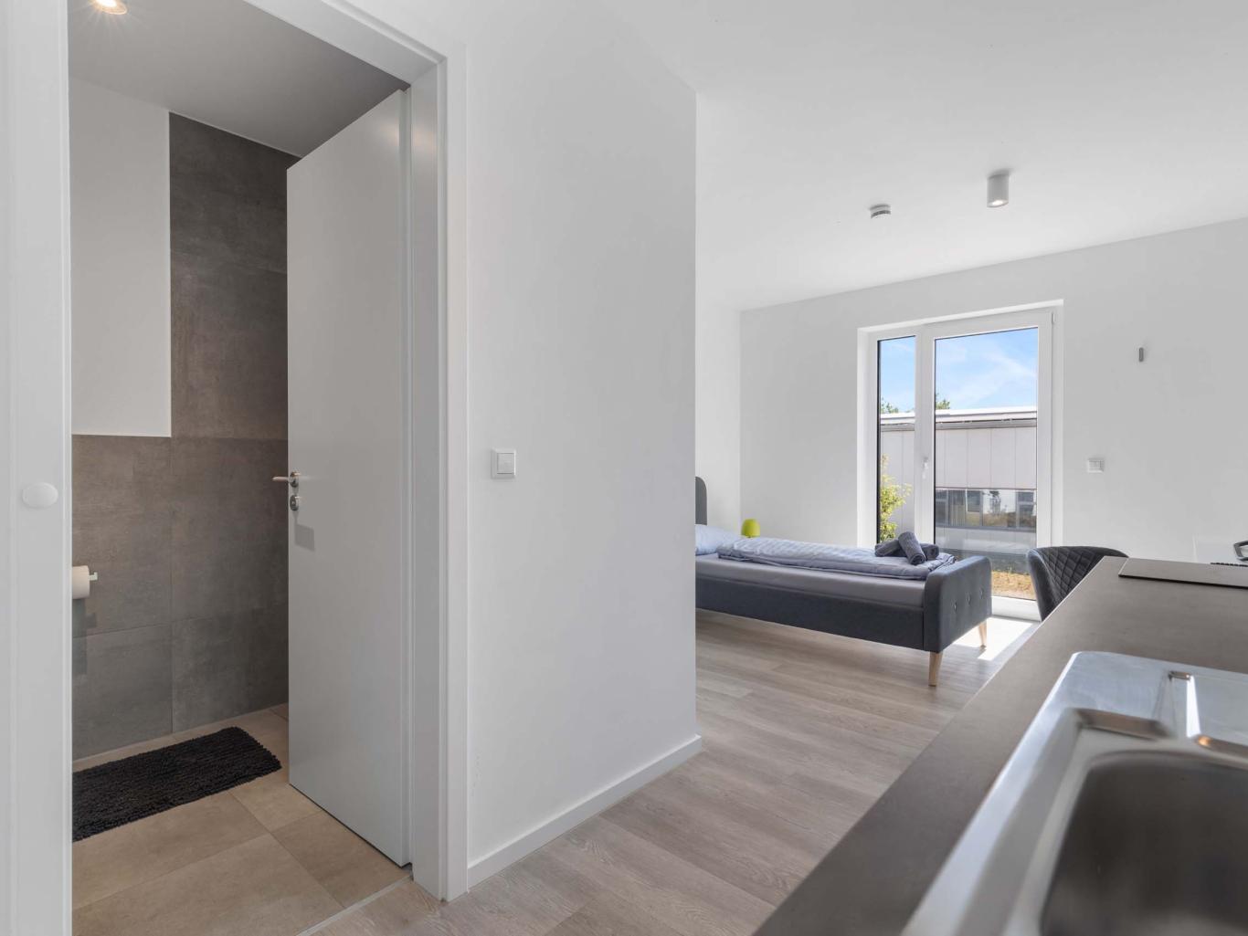 Wohnbereich und Bad mit moderner Einrichtung im LIVINGBOXX® Haus