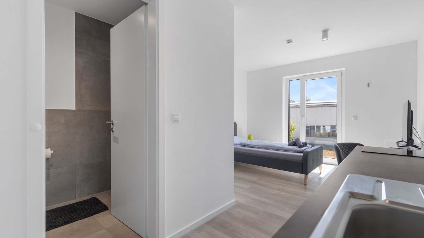 Wohnbereich und Bad mit moderner Einrichtung im LIVINGBOXX® Haus