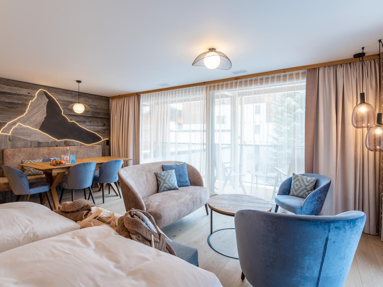 Modernes Zimmer im Resort La Ginabelle Zermatt mit gemütlicher Sitzgruppe und Holzakzenten