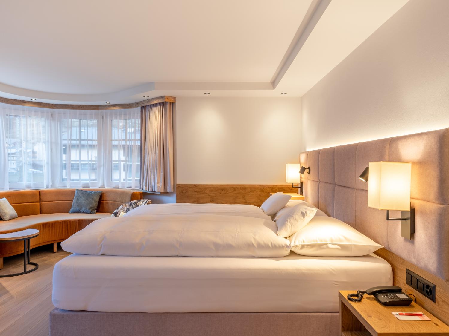 Modernes Zimmer im Resort La Ginabelle Zermatt mit Sitzbereich und Doppelbett