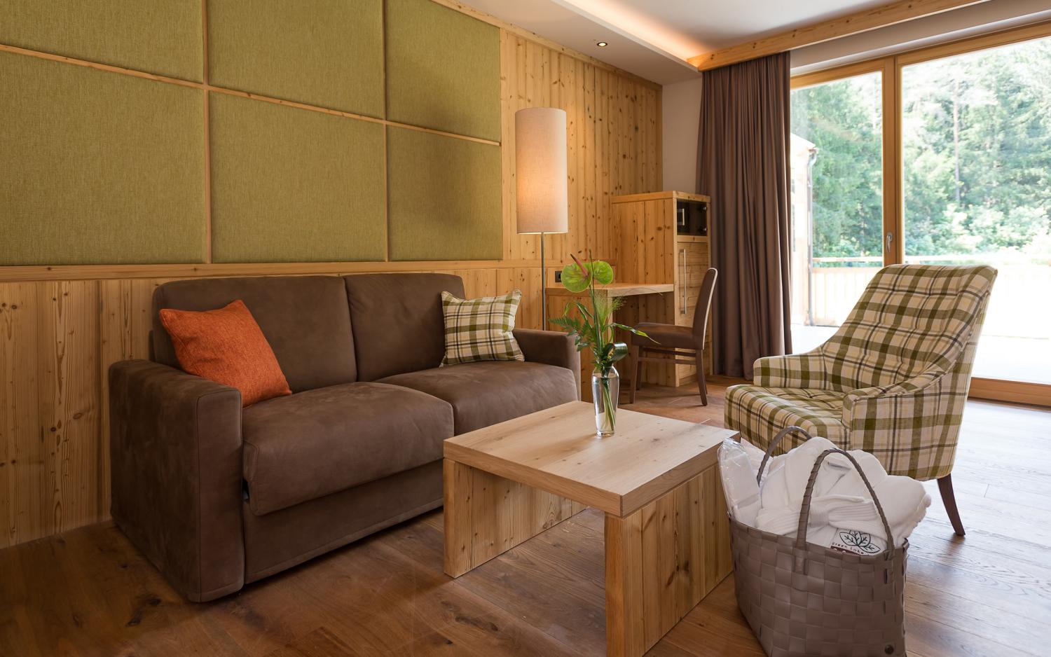 Gemütlicher Wohnbereich im Hotel Weiher mit Sofa und Blick ins Grüne