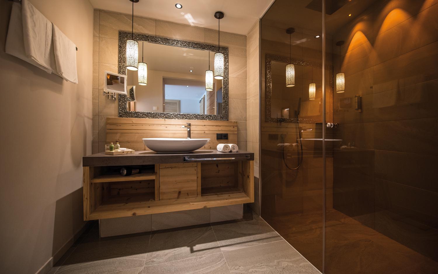 Modernes Badezimmer im Hotel Weiher mit Holzwaschbecken und Spiegel