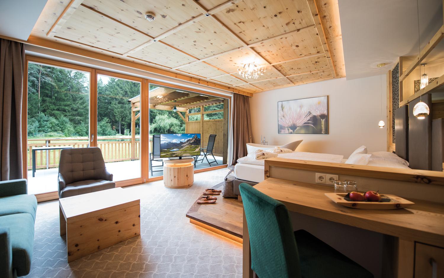 Gemütlicher Wohnbereich mit Holzdecke im Hotel Weiher mit Blick auf Waldterrasse