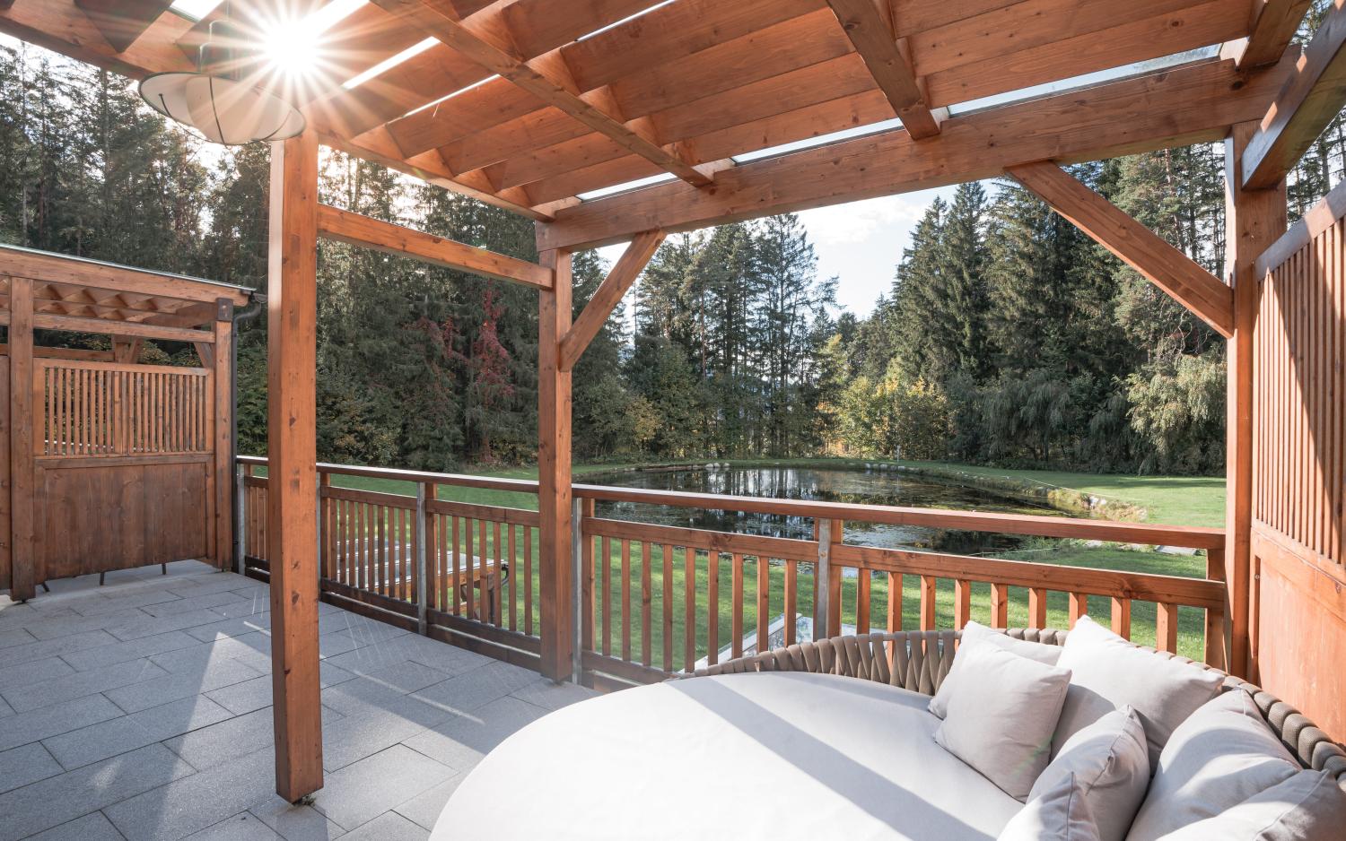 Sonnige Terrasse mit Holzdach und Waldblick im Hotel Weiher