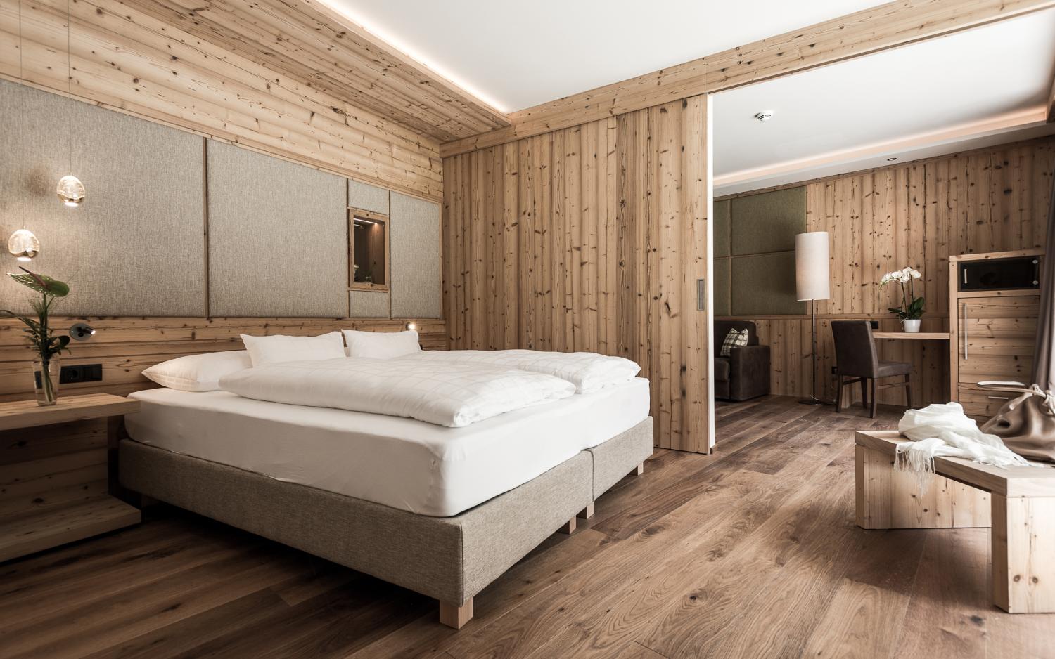 Gemütlicher Wohnbereich im Hotel Weiher mit Holzmöbeln und Balkonblick