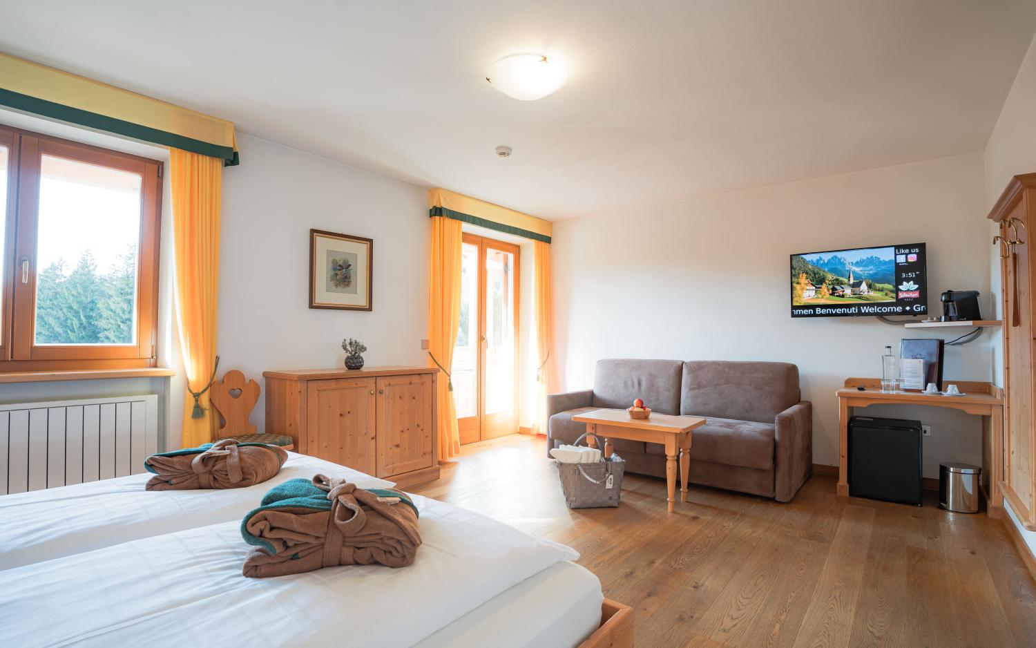 Cozy room at Hotel Weiher with bright curtains and wooden furniture