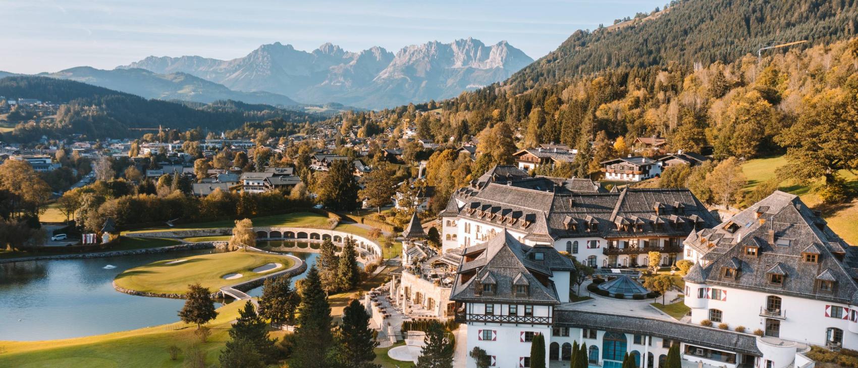 Schlosshotel Kitzbühel am See vor herbstlich gefärbten Bergen