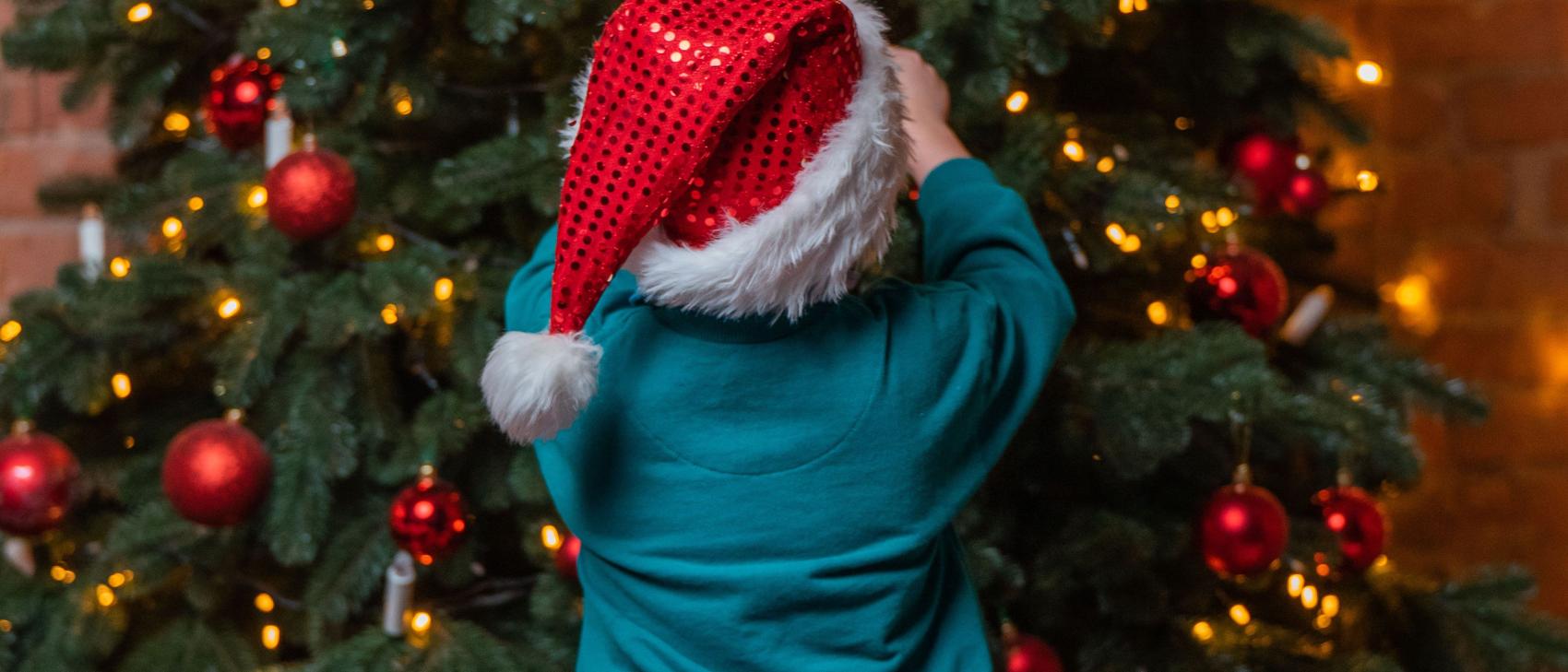 Child decorating the Christmas tree at Schlosshotel Kitzbühel
