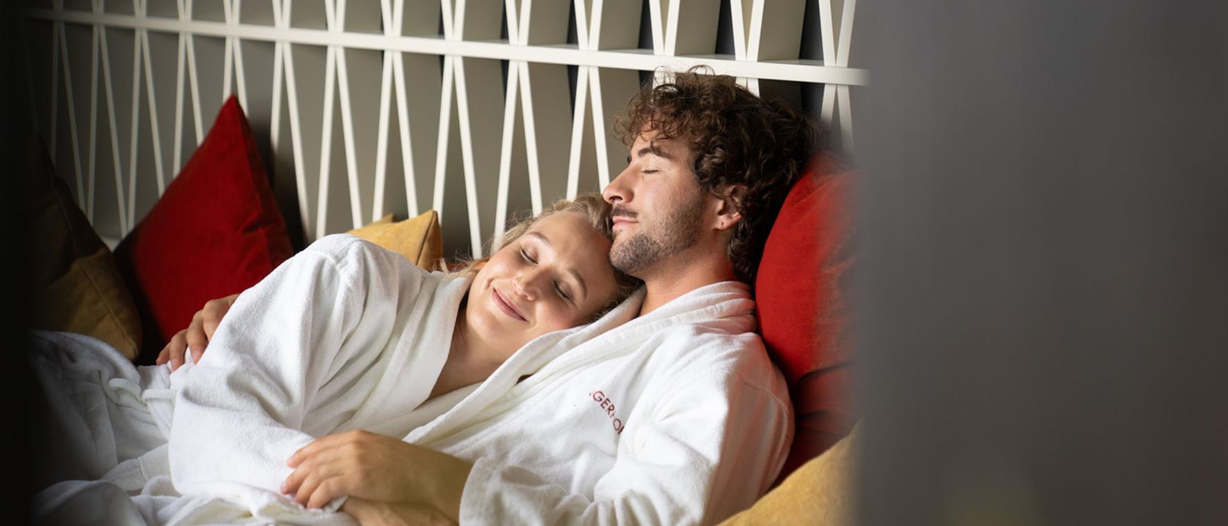Paar entspannt im Sport- und Wellnesshotel Angerhof ****S in weißen Bademänteln