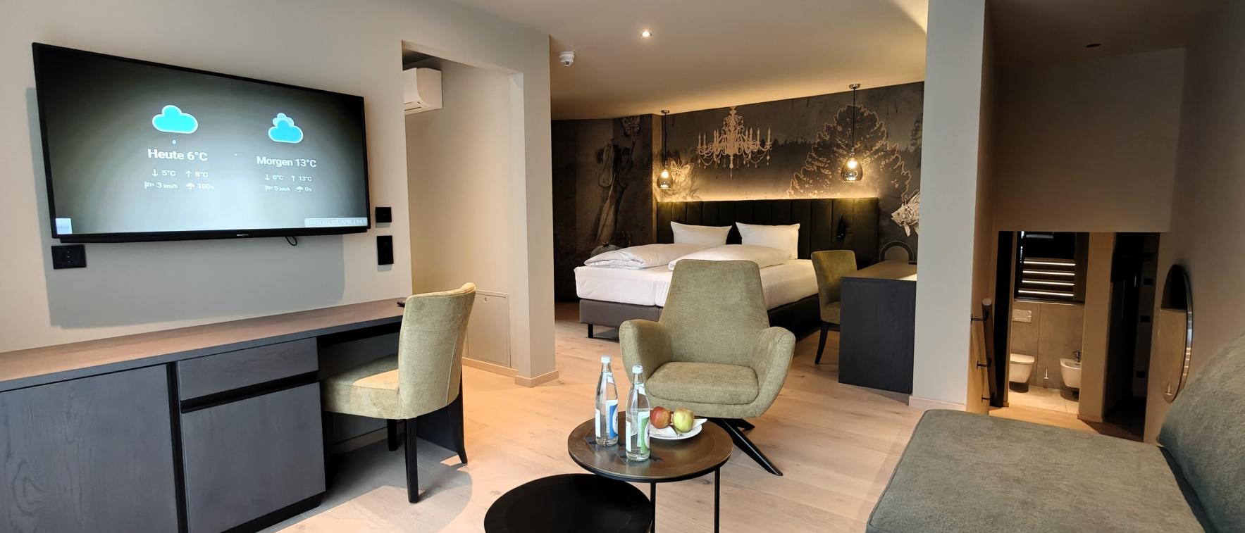 Modernes Hotelzimmer im Sport- und Wellnesshotel Angerhof ****S mit Sitzbereich und TV