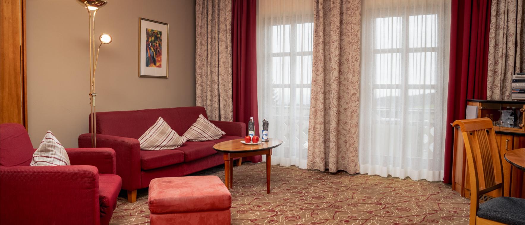 Gemütlicher Wohnbereich im Sport- und Wellnesshotel Angerhof ****S mit roten Möbeln