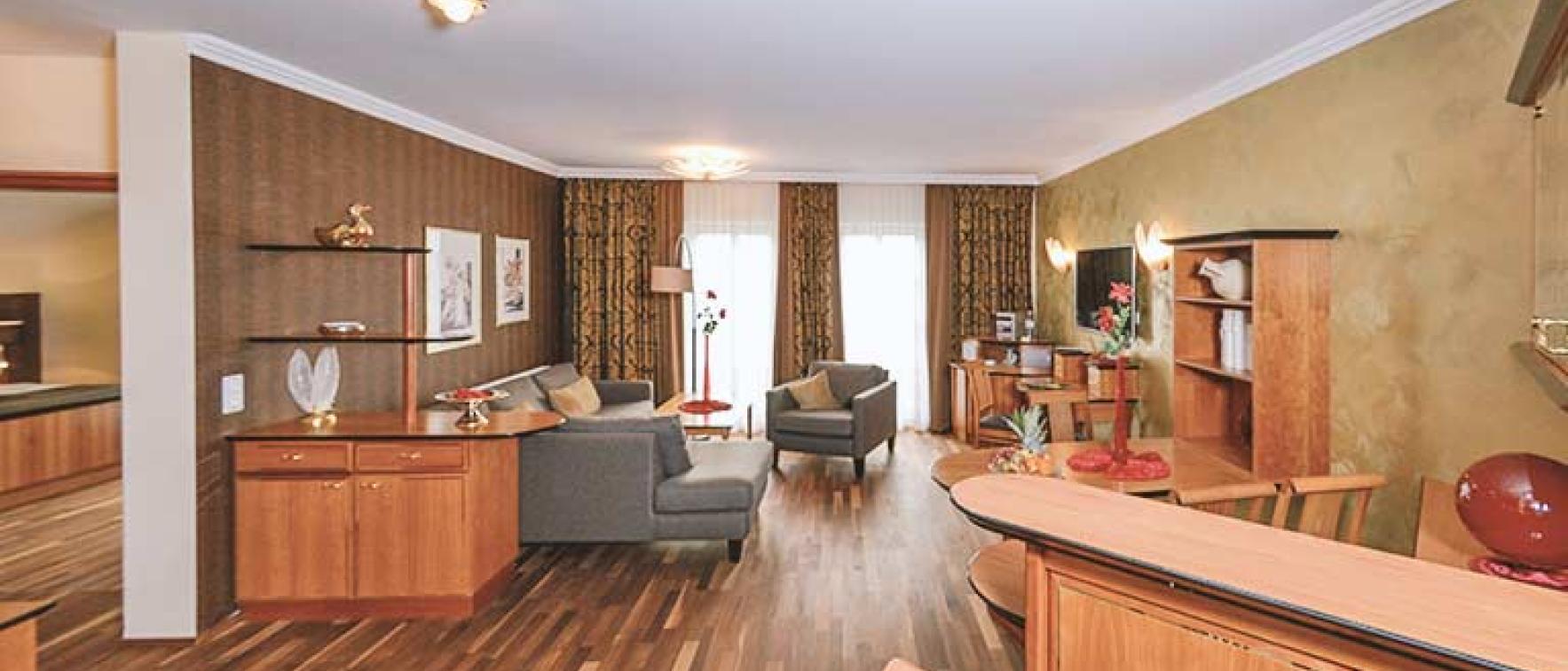 Gemütlicher Wohnbereich im Sport- und Wellnesshotel Angerhof ****S mit Holzmöbeln und Sofas