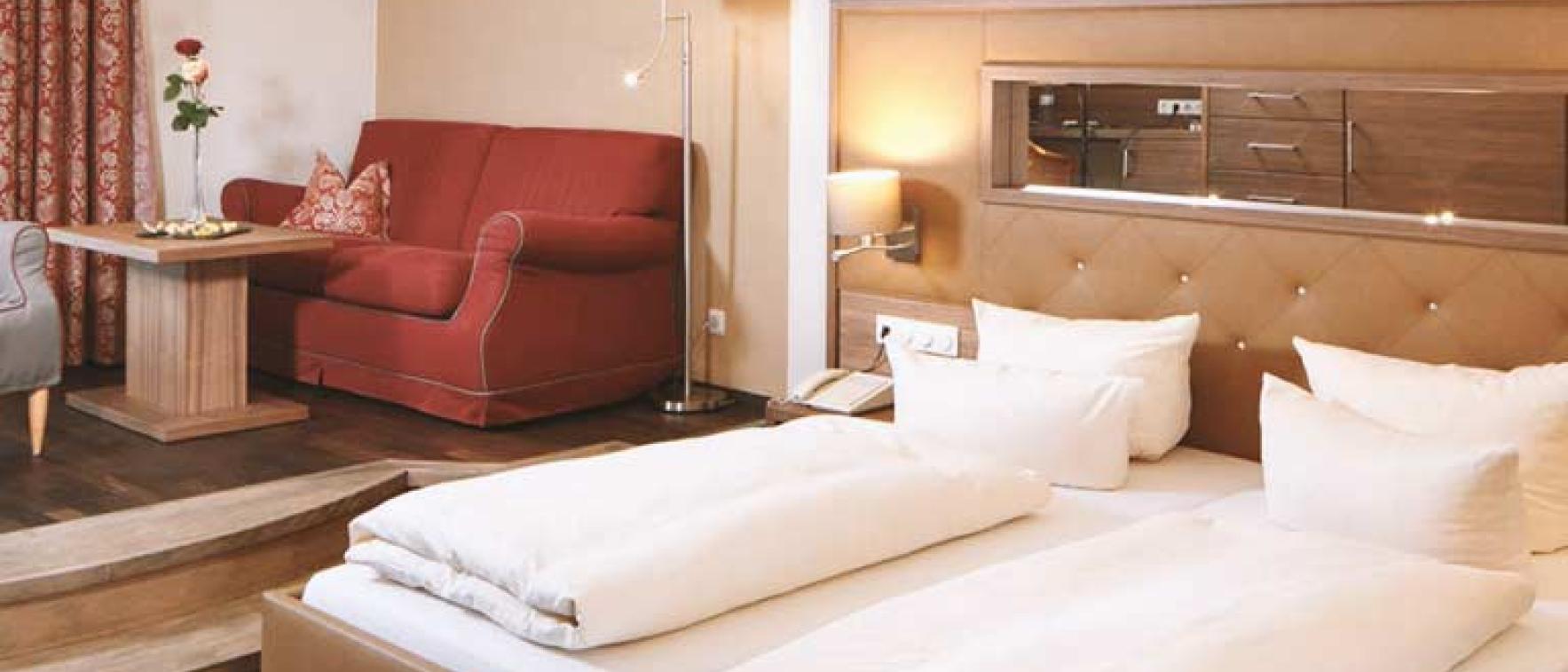 Gemütliches Zimmer im Sport- und Wellnesshotel Angerhof ****S mit Bett und Sofa