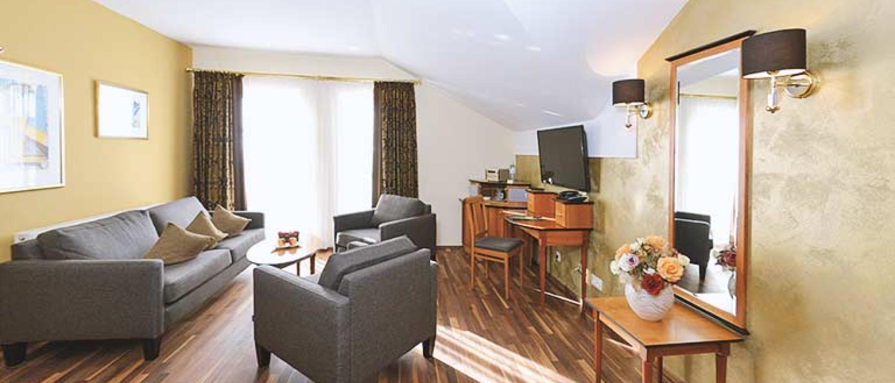 Gemütlicher Wohnbereich im Sport- und Wellnesshotel Angerhof ****S mit Sofas und TV