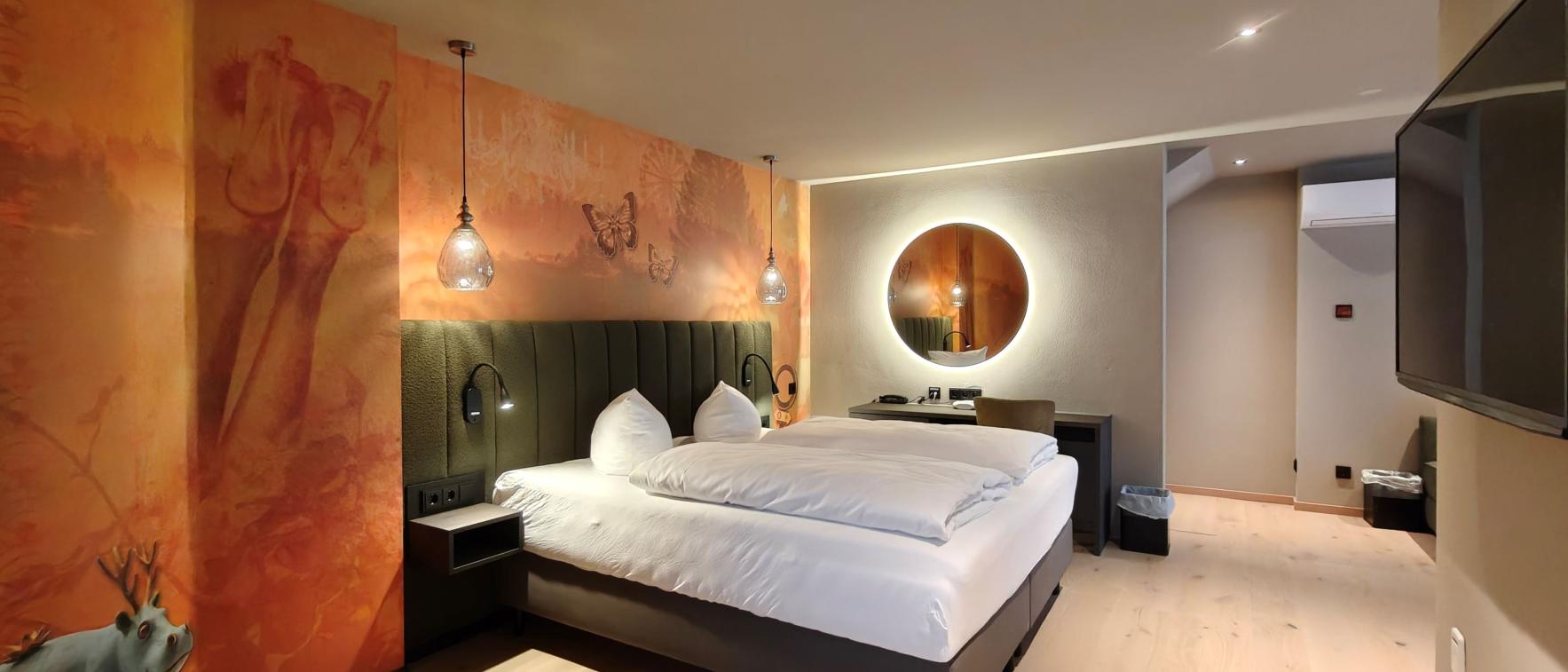 Modernes Hotelzimmer im Sport- und Wellnesshotel Angerhof ****S mit Doppelbett und Wandkunst