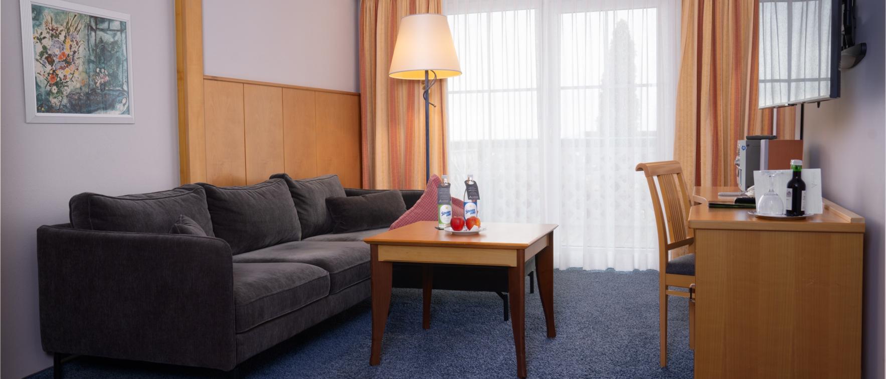 Moderner Wohnbereich im Sport- und Wellnesshotel Angerhof ****S mit Sofa und TV