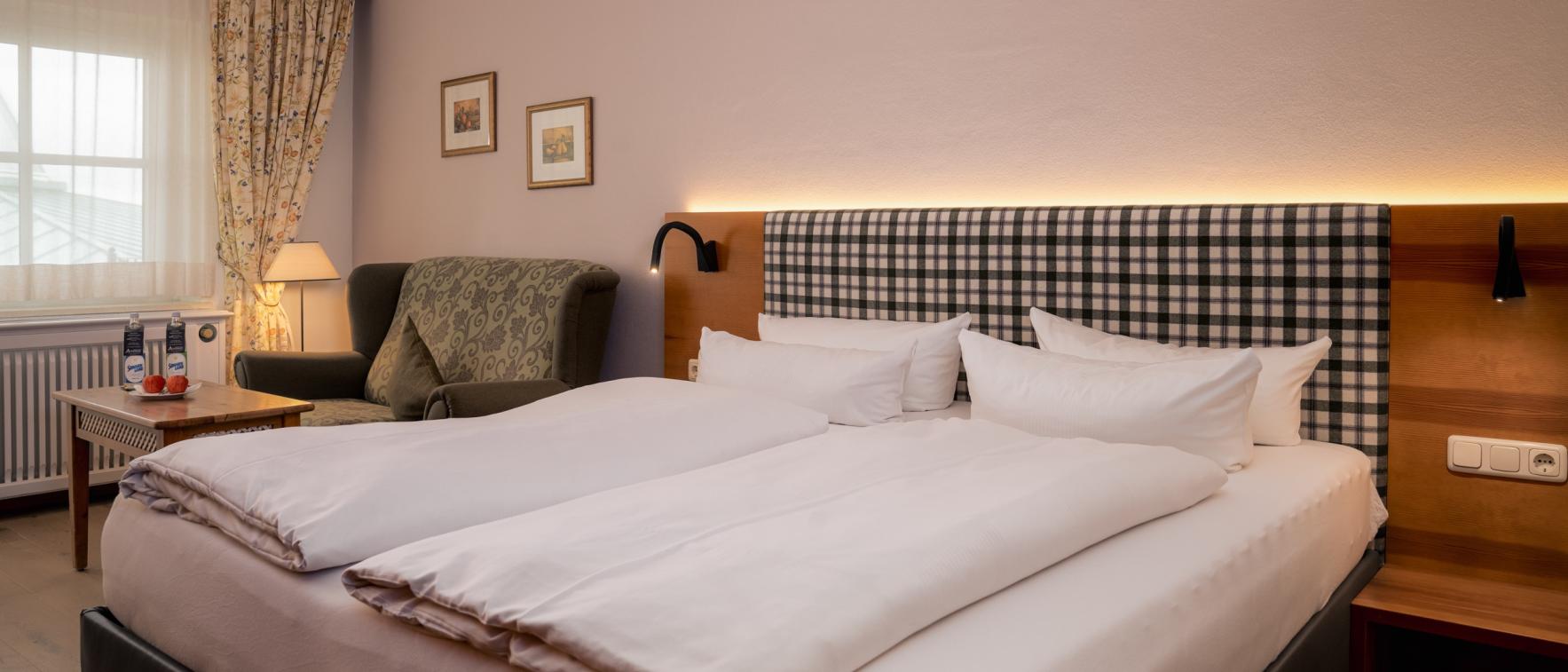 Gemütliches Gästezimmer im Sport- und Wellnesshotel Angerhof ****S mit Doppelbett und Sessel