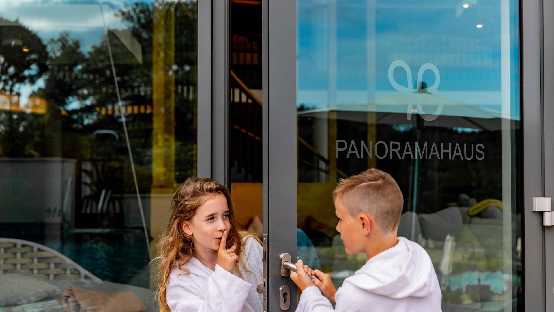 Kinder öffnen die Tür zum Pfalzblick Wald Spa Resort Panoramahaus