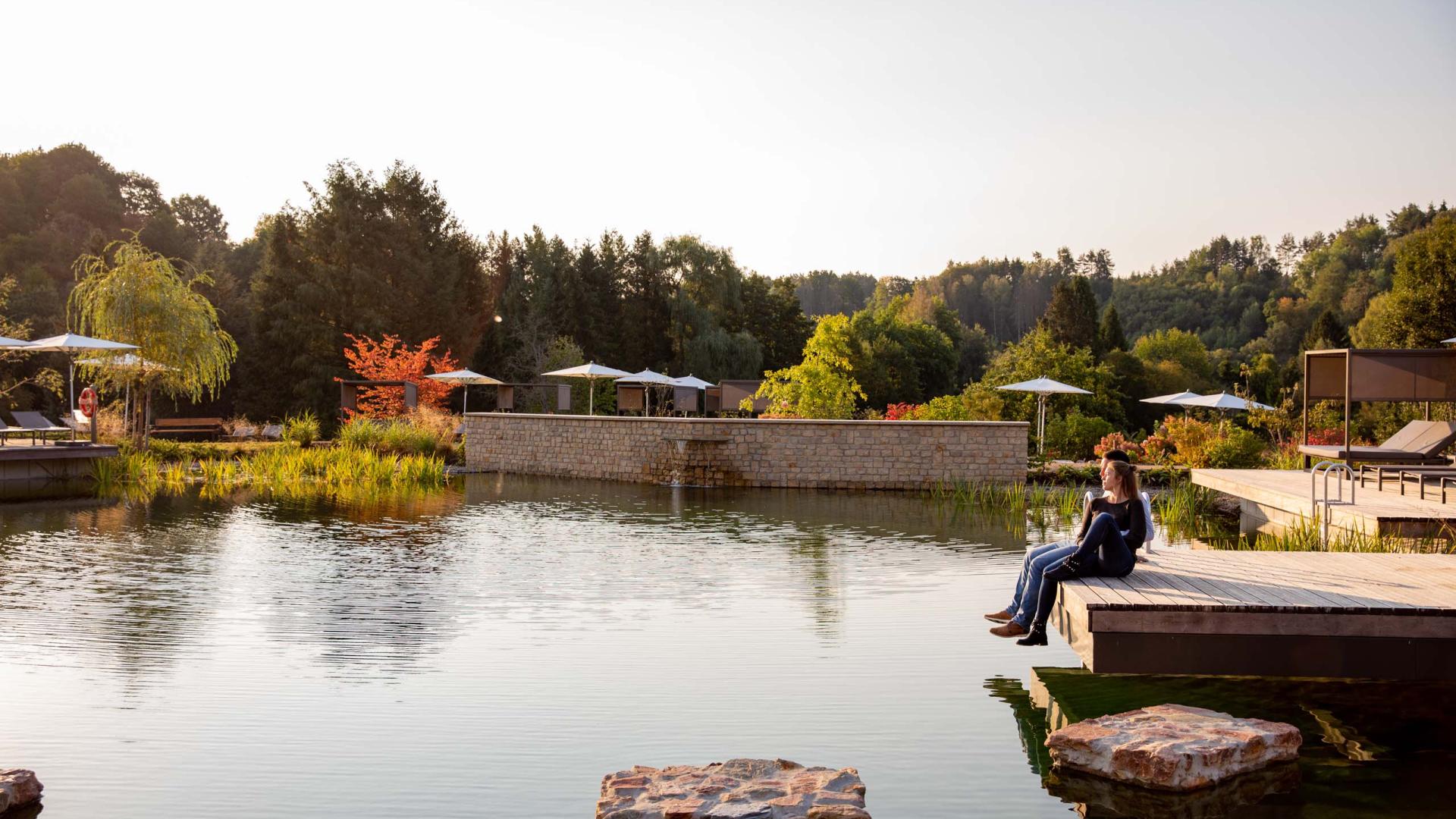 Pfälzblick Wald Spa Resort mit Teich und entspannter Sitzenden in der Natur