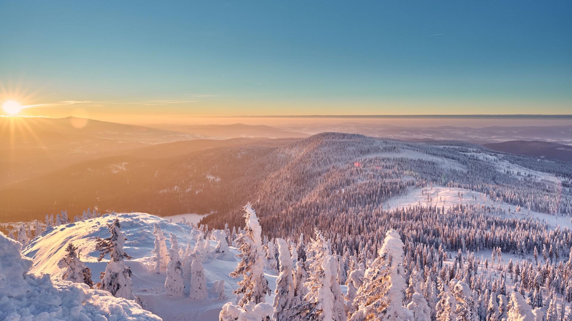 Cubea: Verschneite Bergwälder im warmen Licht des Sonnenaufgangs