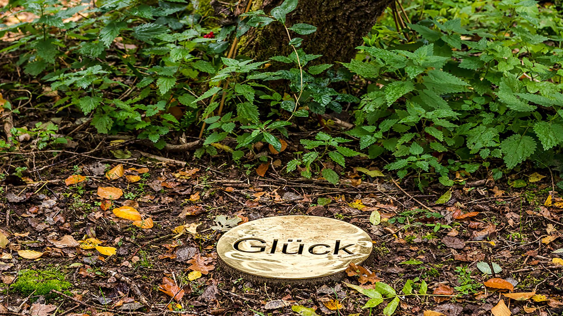 Messingtaler mit der Aufschrift "Glück" im Meditationsbereich zeit raum bei der Seezeitlodge