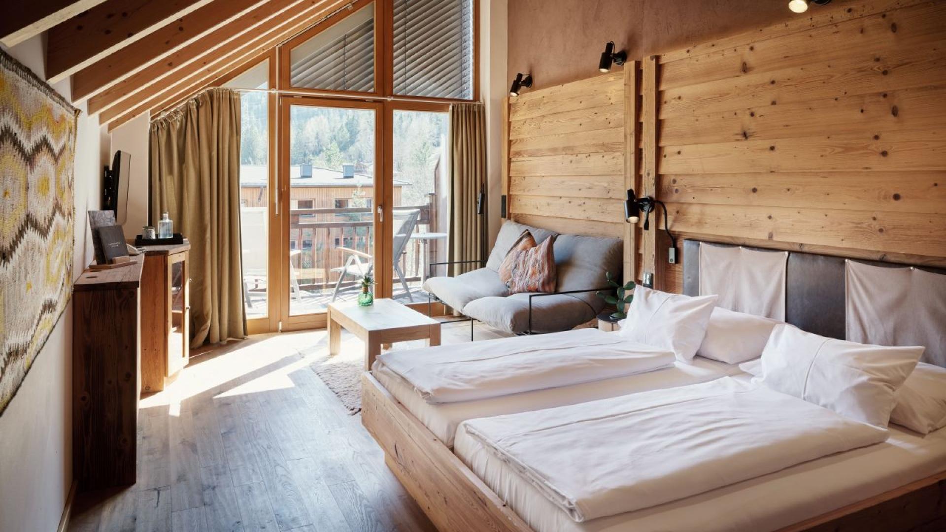 Helles Hotelzimmer mit Holzdekor und Balkon im Hotel MOHR life resort.