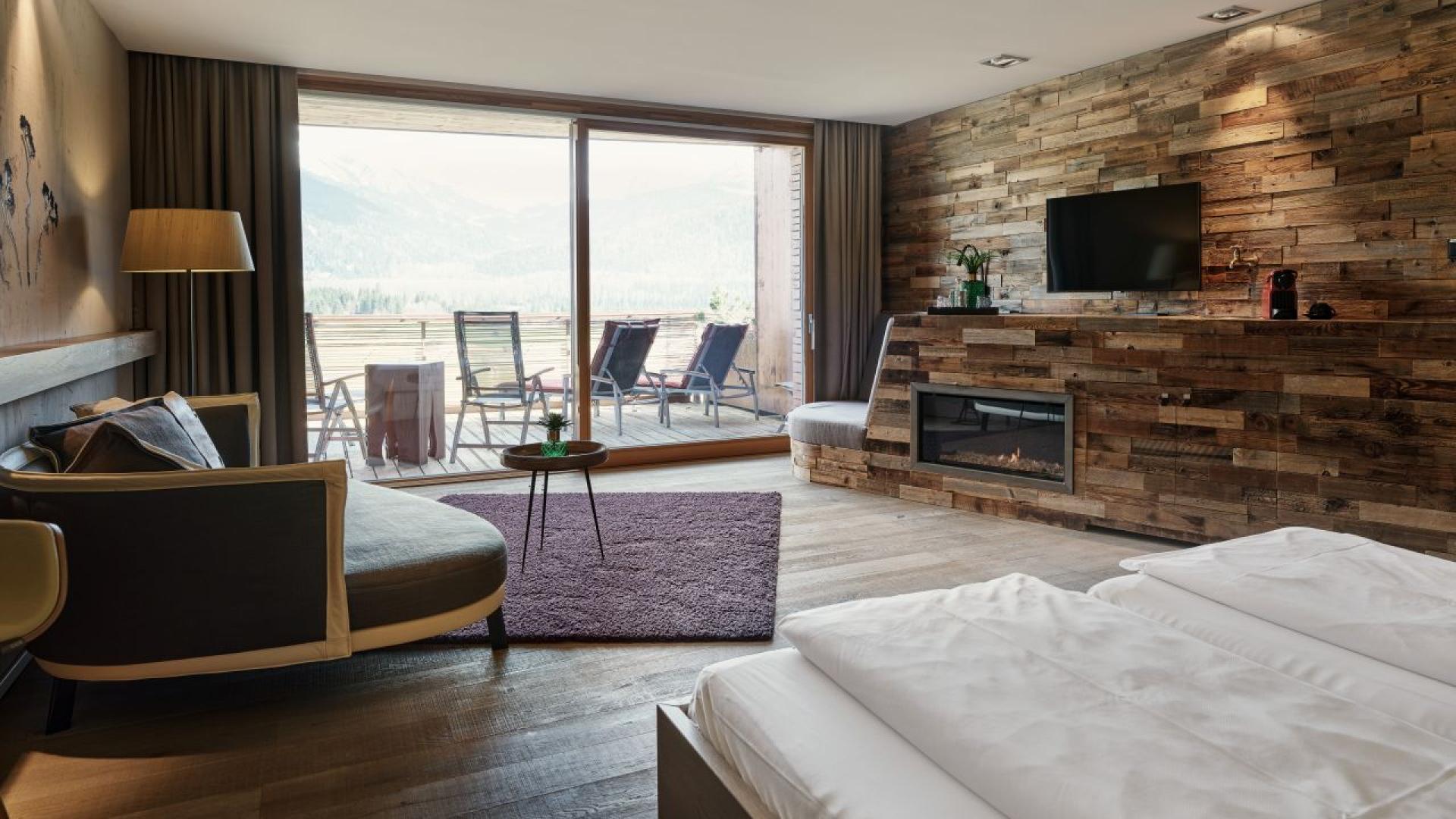 Gemütliches Hotelzimmer im Hotel MOHR life resort mit Holzwand und Terrasse