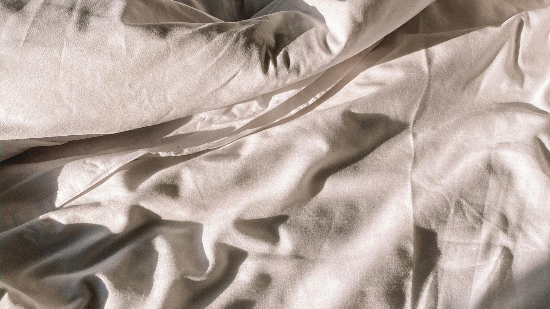 Verwobene weiße Bettwäsche im Hotel Aurora