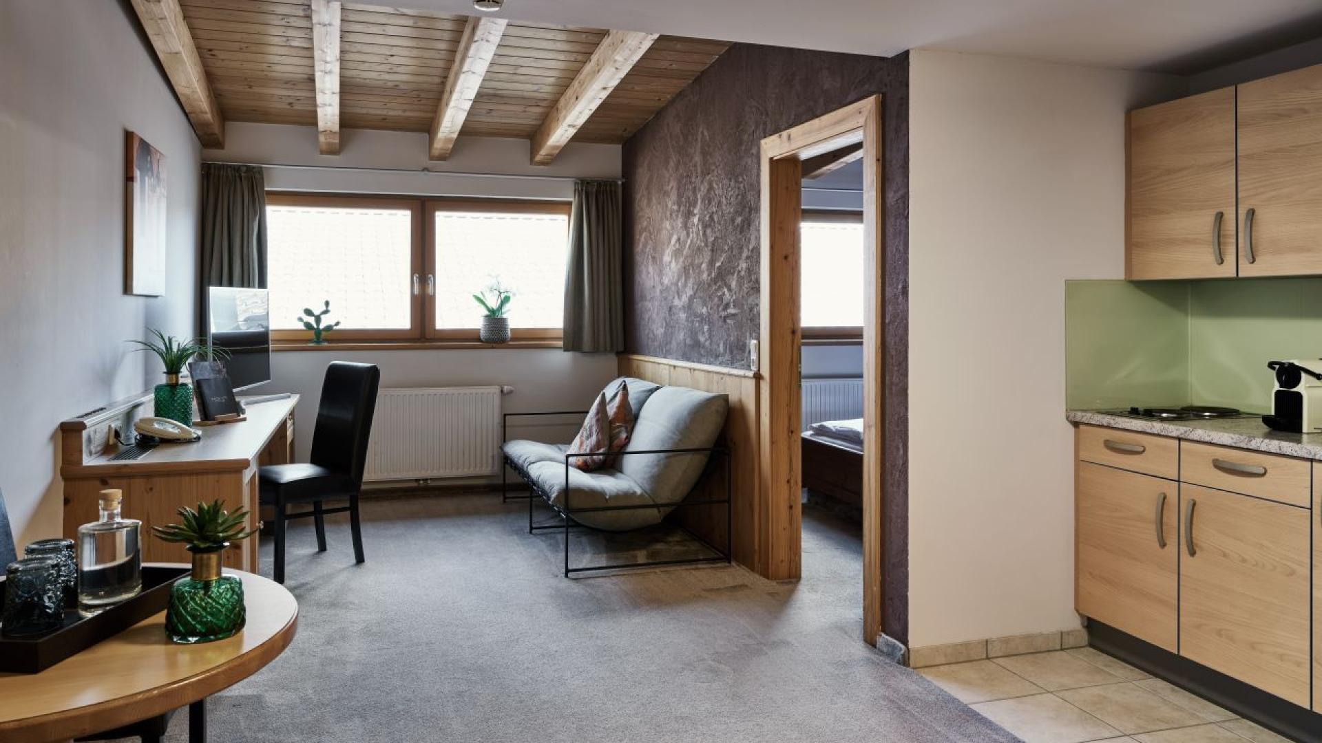 Hotel MOHR life resort Zimmer mit Wohnzimmer, offener Küche und modernem Design