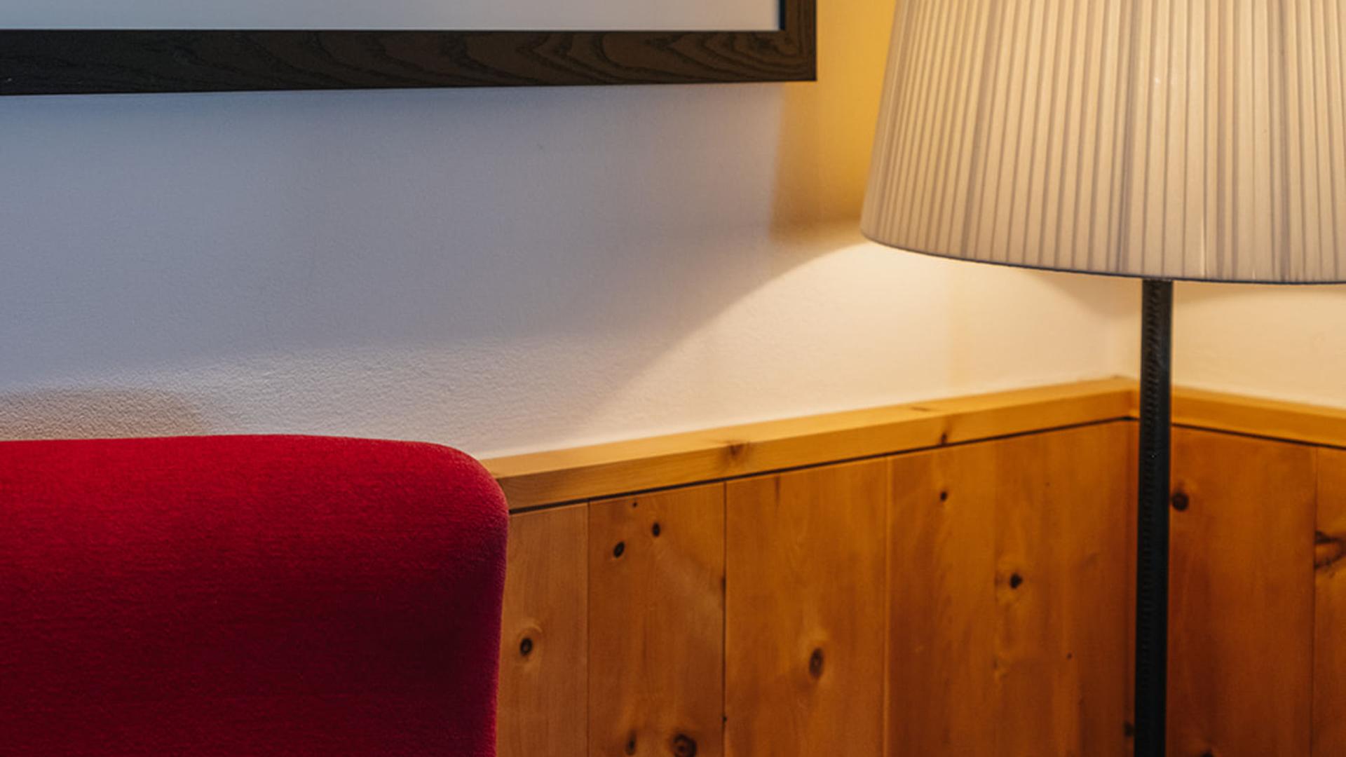 Roter Sessel und Stehlampe in einem Zimmer im Hotel Aurora