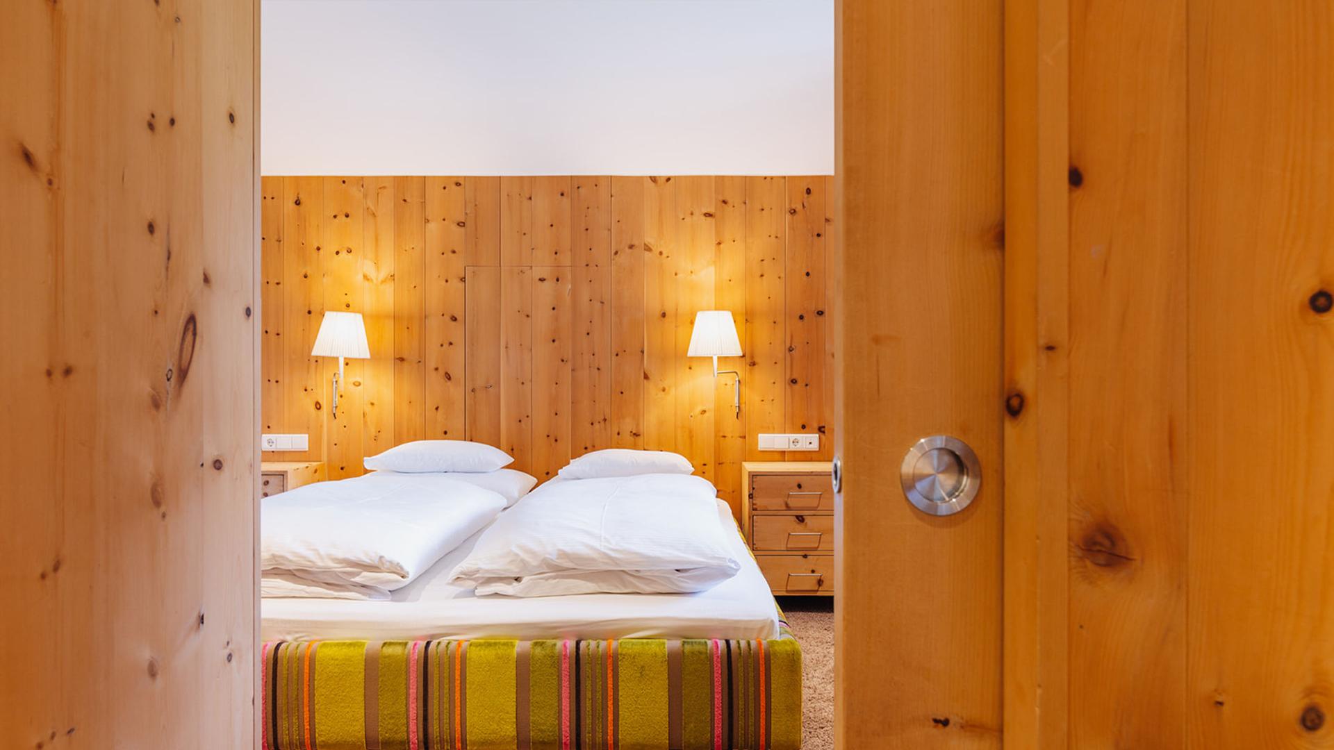 Zimmer im Hotel Aurora mit Holzwänden und zwei Einzelbetten