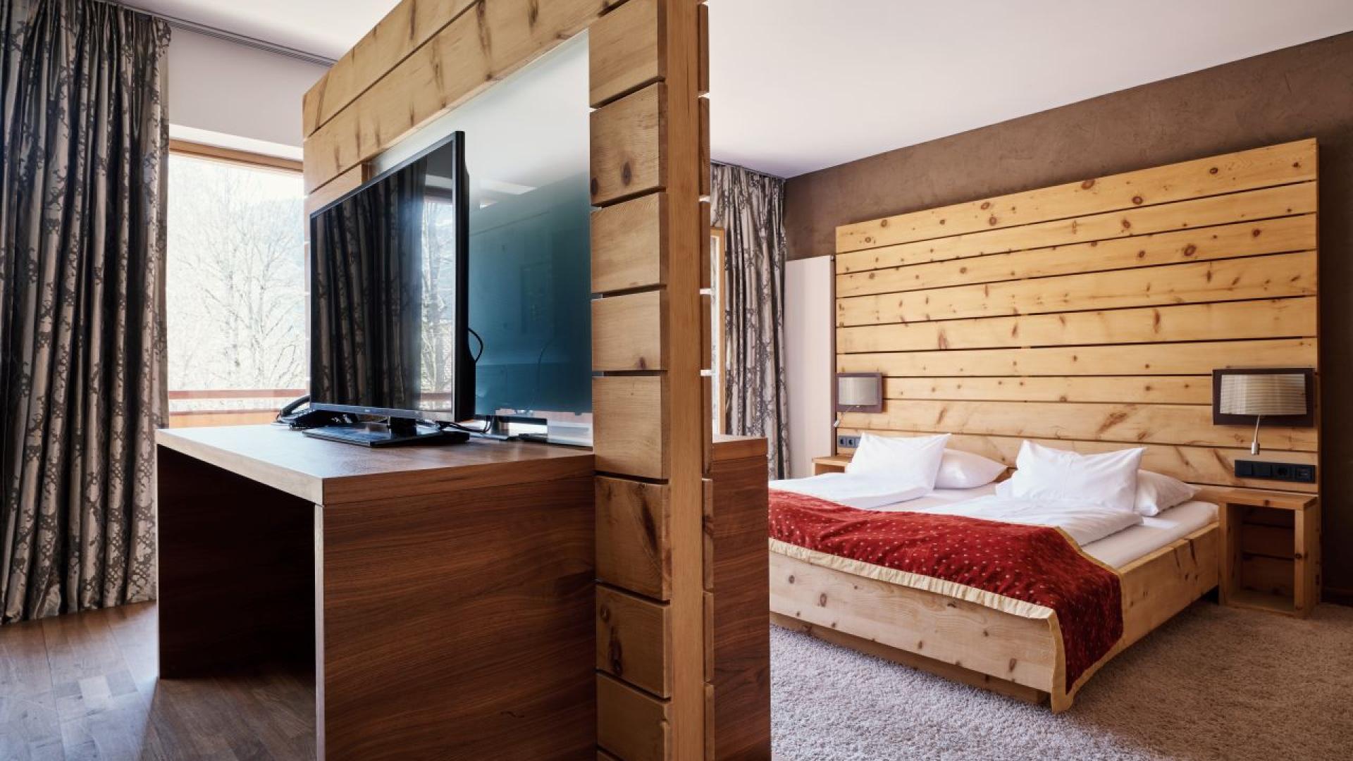 Hotel MOHR life resort geräumiges schlafzimmer mit holzvertäfelung, TV und großem Bett