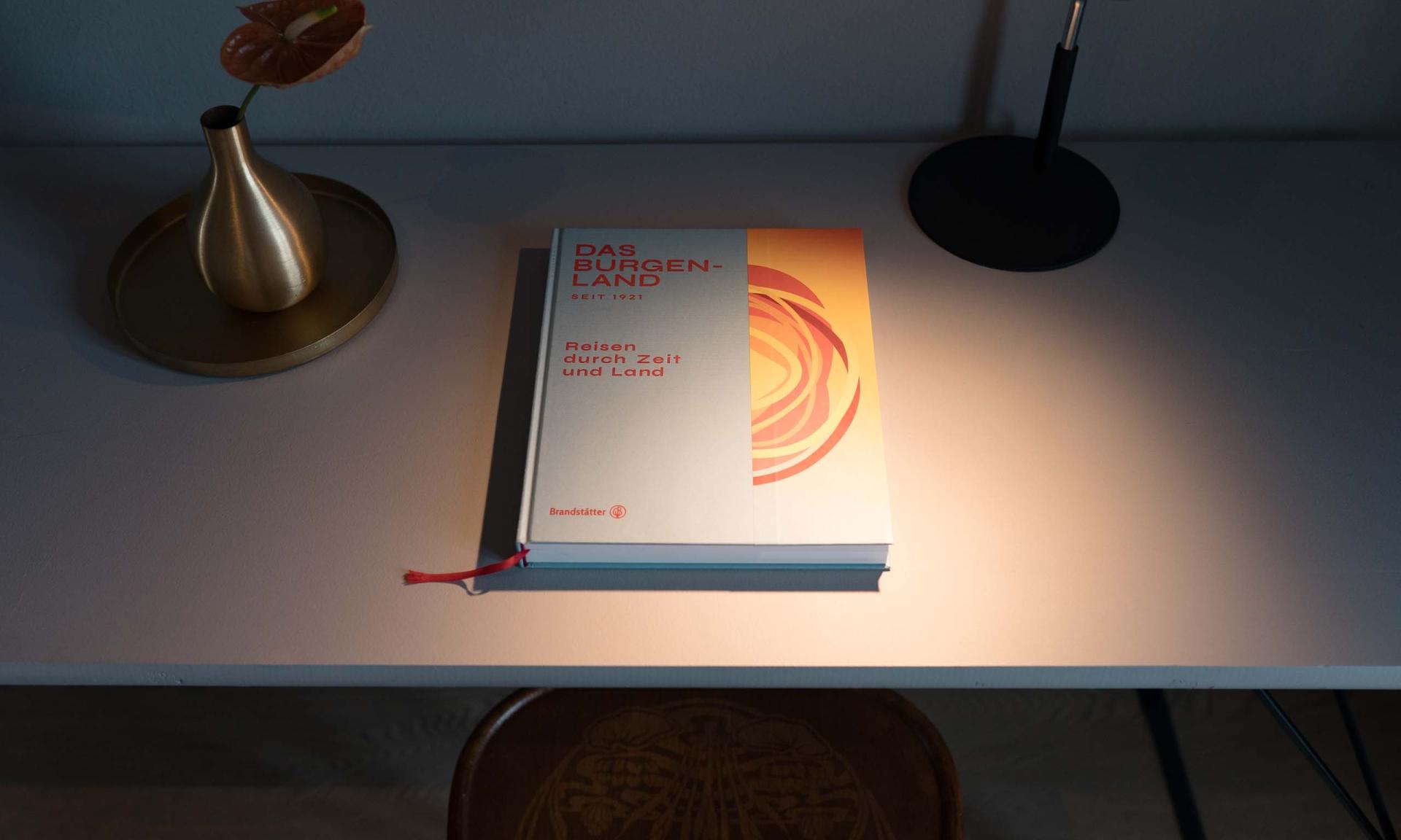 Schreibtisch beleuchtet mit Buch von Luis v. Weyden und modernem Lampendesign