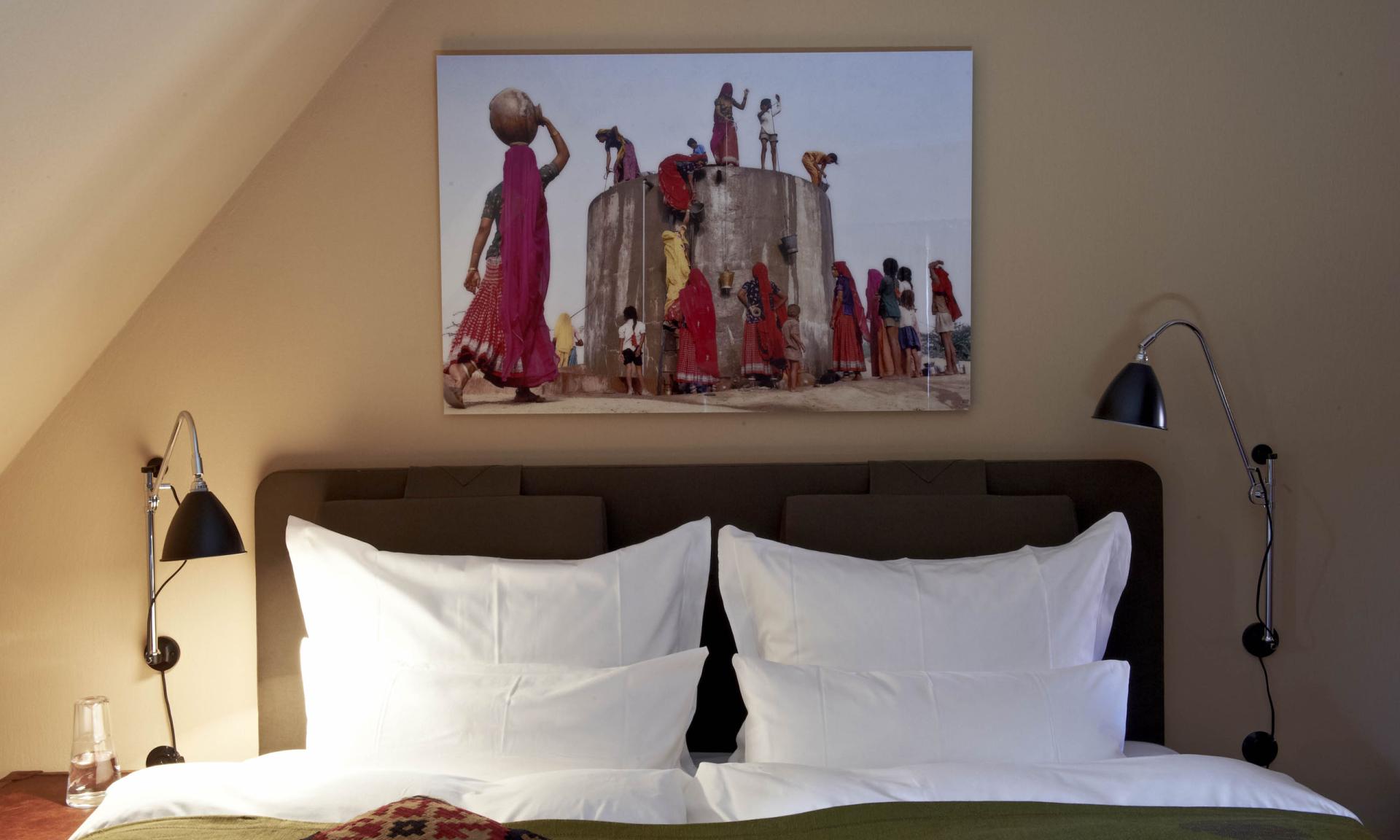 Lösch-Bild über einem Bett zeigt Frauen beim Wasserholen an einem Brunnen