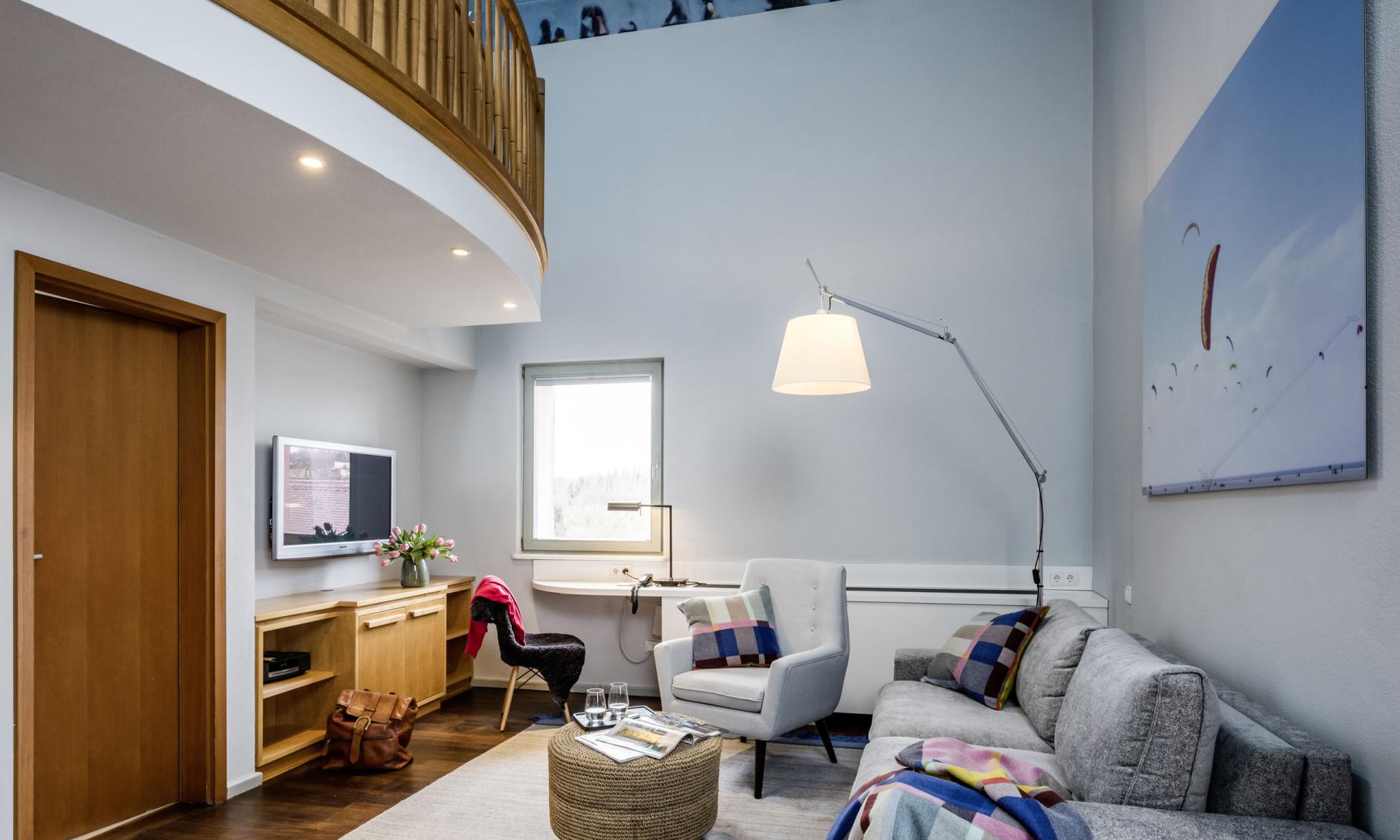 Modernes Wohnzimmer im Kloster Hornbach mit Sitzmöbeln und Holzbalkon