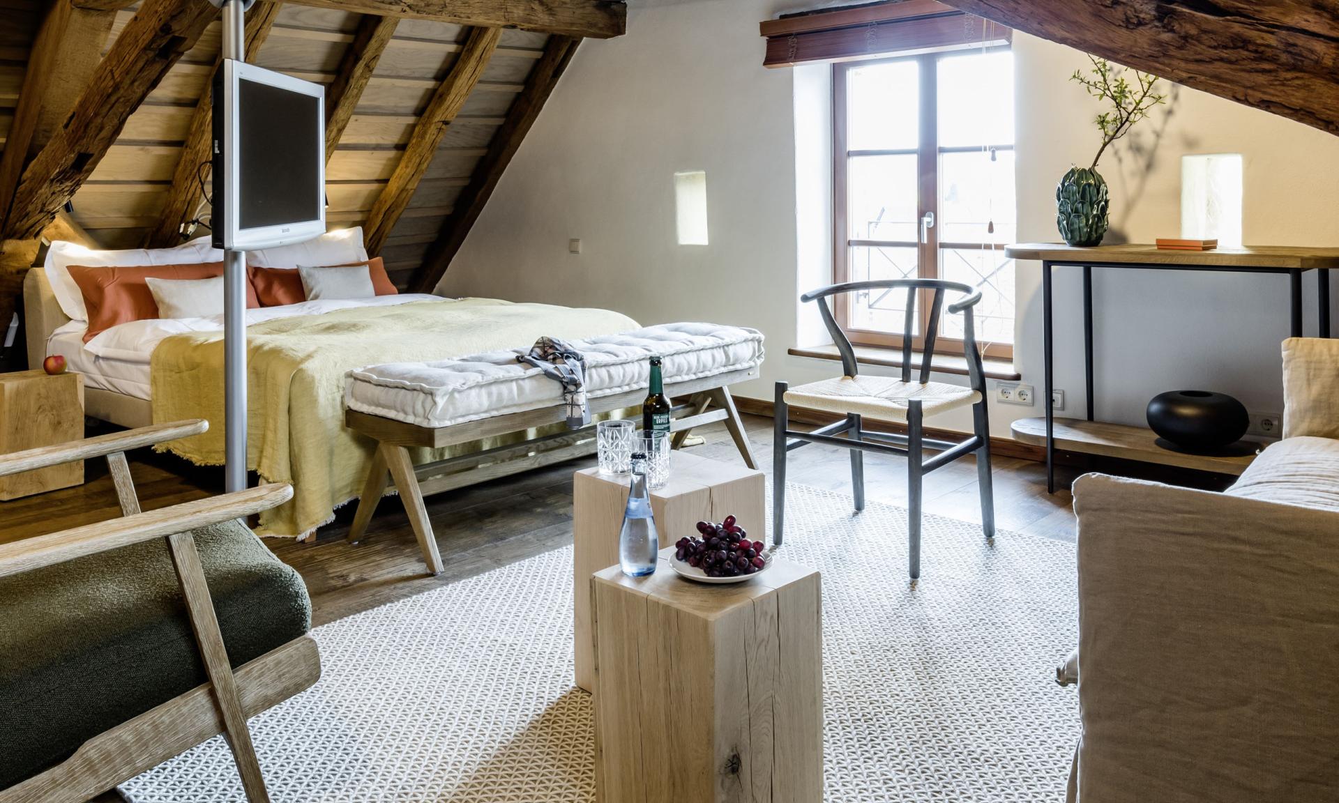 Gemütliches Zimmer im Kloster Hornbach mit sichtbaren Holzbalken und moderner Einrichtung