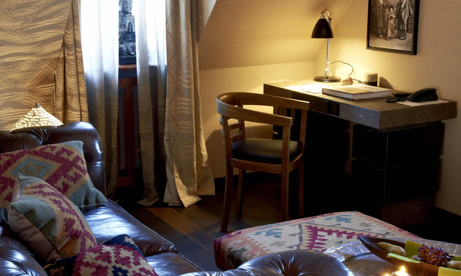 Gemütliches Wohnzimmer mit Löschkerzen auf Tisch und Ledersofa