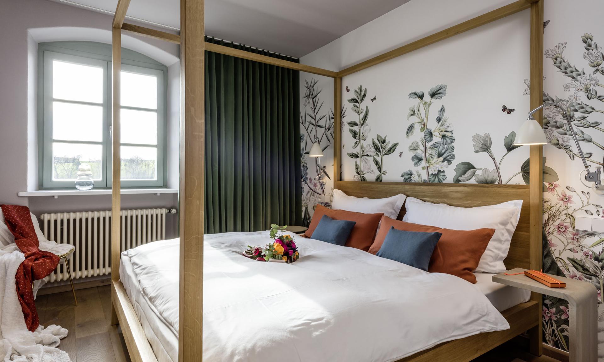 Gemütliches Zimmer im Kloster Hornbach mit Himmelbett und floralem Wanddesign